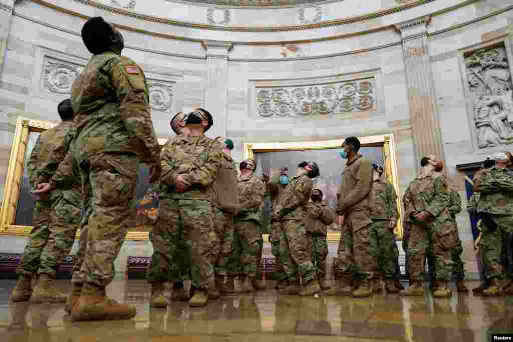 Los soldados observan las obras de arte que adornan el Capitolio durante el tour. 13 de enero de 2021.