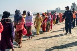 Coast guards escort Rohingya refugees following a boat capsizing accident, in Teknaf on February 11, 2020.