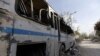 This April 14, 2018 photo shows a destroyed bus near the wreckage of a building described as part of the Scientific Studies and Research Center (SSRC) in the Barzeh district, north of Damascus, Syria.