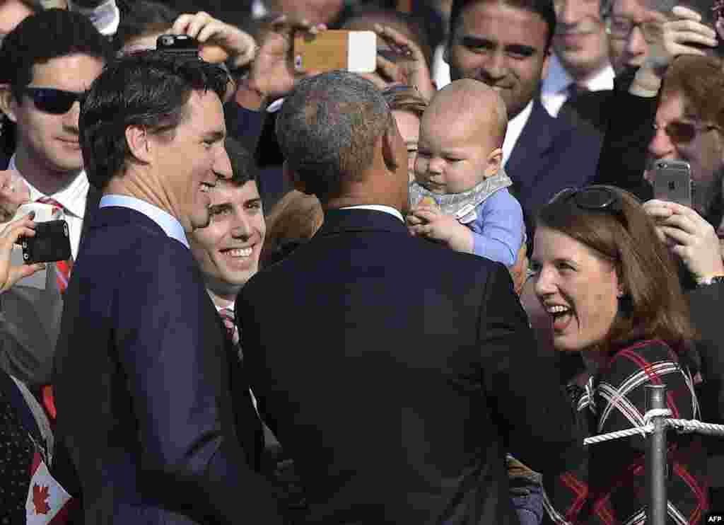 Canada's Prime Minister Justin Trudeau and US President Barack Obama greet visitors as they take part in a welcome ceremony during a State Visit on the South Lawn of the White House on March 10, 2016 in Washington, DC.