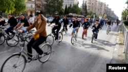 People cycle along a street during a biking tour to promote cycling as an environmentally-friendly means of transport, in Damascus, Syria, Nov. 21, 2014. 