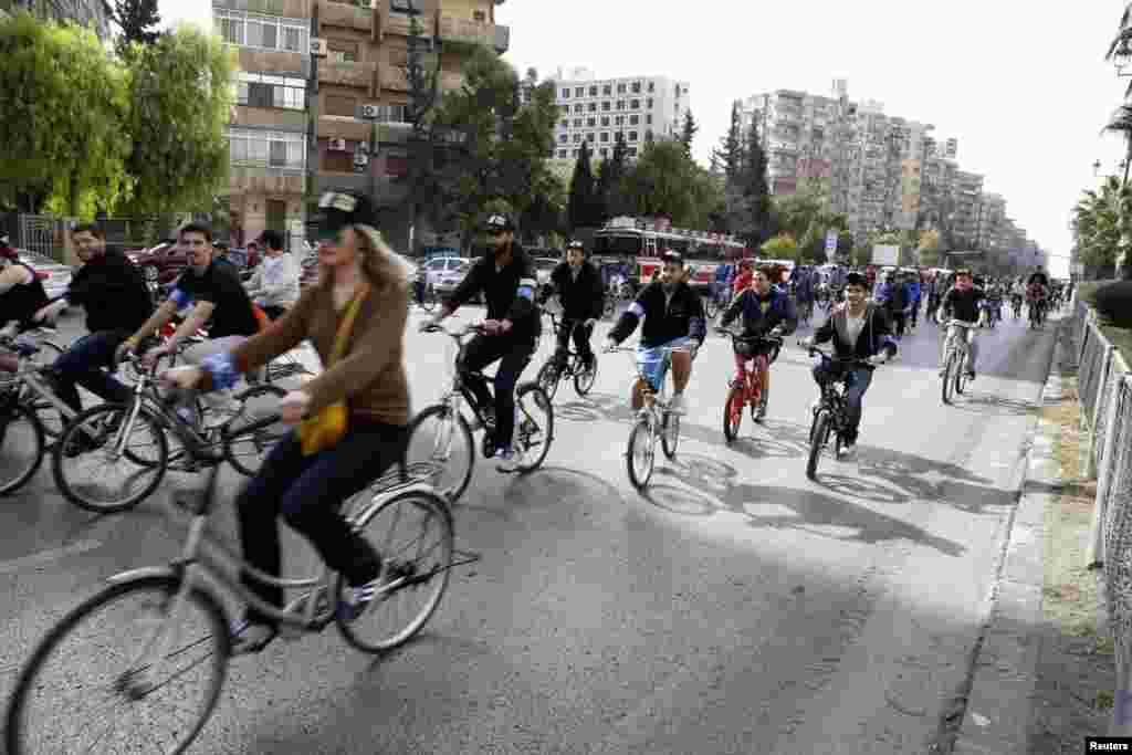 People cycle along a street during a biking tour to promote cycling as an environmentally-friendly means of transport, in Damascus, Syria.