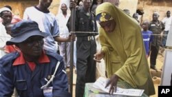 A Muslim woman prepares to vote during a gubernatorial election in Kaduna, Nigeria, Thursday, April 28, 2011. Two states in Nigeria's Muslim north voted Thursday for state gubernatorial candidates after their polls were delayed by violence that killed at 