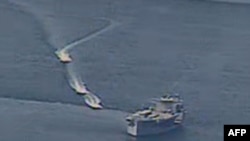 This photo obtained from the U.S. Navy on April 15, 2020, shows Iranian Islamic Revolutionary Guard Corps Navy (IRGCN) vessels conducting unsafe actions against U.S. military ships. The US says 11 Iranian vessels harassed U.S. ships in the Gulf.