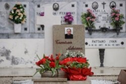 Flowers adorn the tombstone of Adriano Trevisan, Italy's first known victim of COVID-19, at the cemetery of Vo Vecchio, in Vo Euganeo, Feb. 10, 2021.