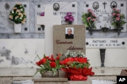 Flowers adorn the tombstone of Adriano Trevisan, Italy's first known victim of COVID-19, at the cemetery of Vo Vecchio, in Vo Euganeo, Feb. 10, 2021.