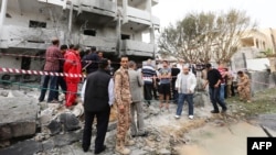 Libyan security forces gather outside the French embassy building in Tripoli following a car bomb attack, April 23, 2013.