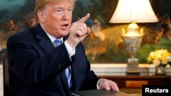 FILE - U.S. President Donald Trump speaks to reporters after signing a proclamation declaring his intention to withdraw from the JCPOA Iran nuclear agreement in the Diplomatic Room at the White House in Washington, May 8, 2018.