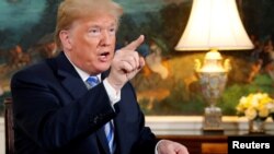 FILE - U.S. President Donald Trump speaks to reporters after signing a proclamation declaring his intention to withdraw from the JCPOA Iran nuclear agreement in the Diplomatic Room at the White House in Washington, May 8, 2018.