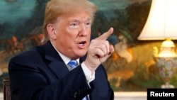 FILE - U.S. President Donald Trump speaks to reporters after signing a proclamation declaring his intention to withdraw from the JCPOA Iran nuclear agreement in the Diplomatic Room at the White House in Washington, May 8, 2018.