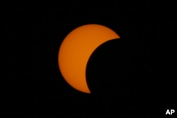 FILE - A partial solar eclipse occurs March 9, 2016, as seen from Taguig city, east of Manila, Philippines.