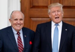 FILE - President-elect Donald Trump calls out to media as he and former New York Mayor Rudy Giuliani pose for photographs as Giuliani arrives at the Trump National Golf Club Bedminster clubhouse, Nov. 20, 2016, in Bedminster, N.J.