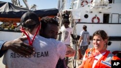 In this photo taken Aug. 9, 2018, migrants disembark from the Open Arms boat, in Algeciras, Spain, after being rescued off the coast of Libya in the early hours of Aug. 2, 2018. 
