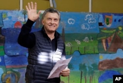 Argentina's President Mauricio Macri waves to followers before voting during the open primary legislative elections in Buenos Aires, Argentina, Aug. 13, 2017.