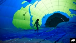 An environmental activist walks inside a hot air balloon before launching it during a demonstration outside of an EU summit in Brussels.