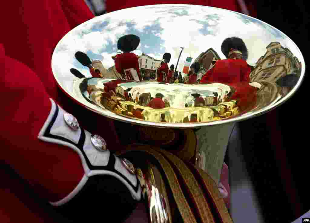 Members of the Band of the Irish Guards are reflected in an brass instrument during the Welcome Ceremony of the Irish President Michael D. Higgins in the town of Windsor, west of London.