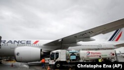Workers refuel an Airbus A350 airplane at Roissy airport, north of Paris on May 18, 2021. Major airlines like Air France are counting on additional flexibility to avoid having to fly empty or near-empty flights. (AP Photo/Christophe Ena, File)