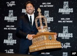 New York Rangers' Henrik Lunqvist poses with the Vezina Trophy after winning the award for the league's best goalie, June 20, 2012, in Las Vegas.