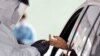 A woman's blood is collected for testing of coronavirus antibodies at a drive-through testing site in Hempstead, N.Y., April 14, 2020. 