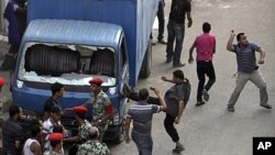 Protesters kick a police car, smash the windows and throw stones at the court complex in Suez, about 110km (68 miles) northeast of Cairo, Egypt, July 6, 2011