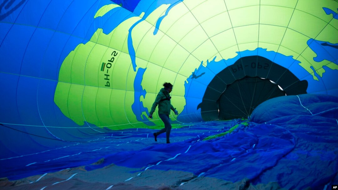 An environmental activist walks inside a hot air balloon before launching it during a demonstration outside of an EU summit in Brussels.