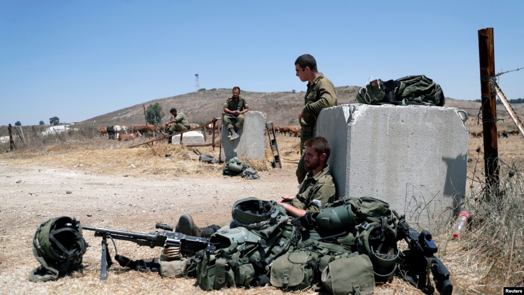 Tentara Israel tampak beristirahat di dekat gerbang di wilayah Dataran Tinggi Golan yang berlokasi di dekat perbatasan Israel dan Suriah, pada 3 Agustus 2020. (Foto: Reuters/Ronen Zvulun)