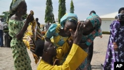 Anggota keluarga meluapkan kegembiraan mereka dengan merangkul kerabat mereka yang merupakan salah satu anak sekolah yang diculik, di Abuja, Nigeria, 20 Mei 2017. (Foto: dok). Ke-82 anak sekolah Nigeria yang baru-baru ini dilepaskan setelah lebih dari tiga tahun diculik oleh Boko Haram.