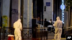 Members of the bomb squad search for evidence outside Labor Ministry in Athens, Dec. 12, 2016. 