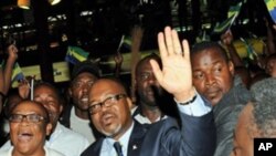 Andre Mba Obame (C) (AMO) greets supporters upon his arrival at the airport Leon Mba in Libreville, 30 Dec 2010