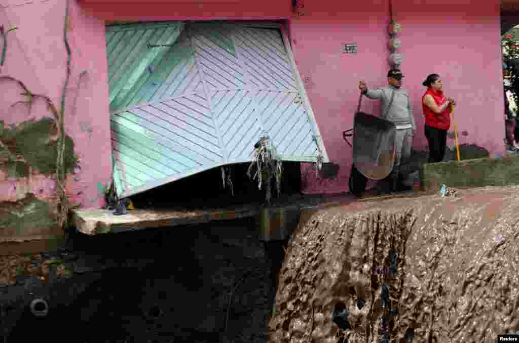 People look at the damage caused by heavy rainfall in the municipality of Ecatepec, that left two persons missing and damaged cars and infrastructure, in the outskirts of Mexico City, Mexico, Sept. 7, 2021.