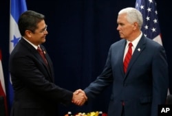 El presidente de Honduras, Juan Orlando Hernandez (izq.) saluda al vicepresidente de EE.UU., Mike Pence durante la Conferencia sobre Prosperidad y Seguridad en Centroamérica. Miami, Florida. Junio 15, 2017.