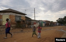 FILE - Children play below illegally connected electrical wires in Kliptown, Soweto. The horrors of 1976 seem distant for today’s children.