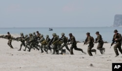 FILE - U.S. and Philippine marines storm the beach to simulate a raid during a joint U.S.-Philippines military exercise at the Naval Training Exercise Command, a former U.S. naval base, at San Antonio township, Zambales province, northwest of Manila, Philippines, May 9, 2014.