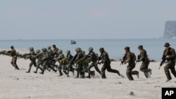 FILE - U.S. and Philippine marines storm the beach to simulate a raid during the joint U.S.-Philippines military exercise at the Naval Training Exercise Command in Zambales province, northwest of Manila, May 9, 2014.