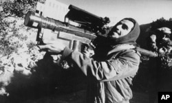 FILE - An Afghan guerrilla handles a U.S.-made Stinger anti-aircraft missile in this photo made between November 1987 and January 1988.