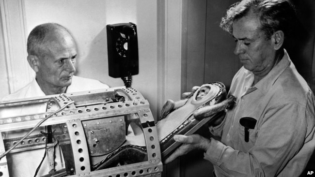 This NASA photo shows Dr. Hugh Blodgett (left) and Dr. Lynn Brown, both of the University of Texas, placing a monkey in a container during a pre-flight test. This actual launch was on December 4, 1959, at Wallops Island, Virginia. (AP Photo/NASA)