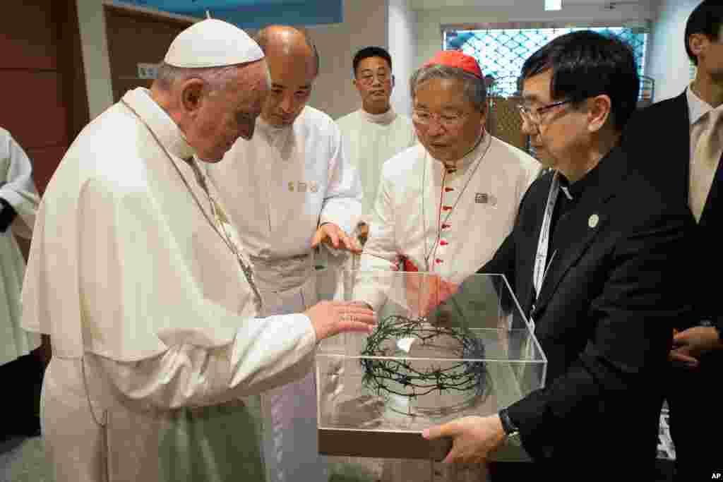 Pope Francis blesses a crown of barbed wire taken from the border between South and North Korea that resembles the crown of thorns worn by Jesus Christ, prior to the start of a Mass of reconciliation in Seoul, South Korea, Aug. 18, 2014.