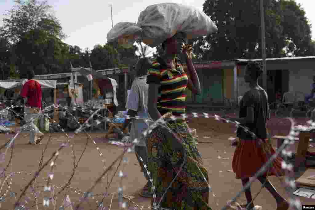 Uma mulher carrega na cabeça os seus bens a caminho do posto de controlo no Quilómetro 12 em Bangui, Março&nbsp; 3, 2014. 