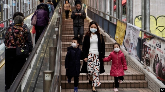 戴着口罩的香港市民在金融区一带行走。（2020年2月19日）