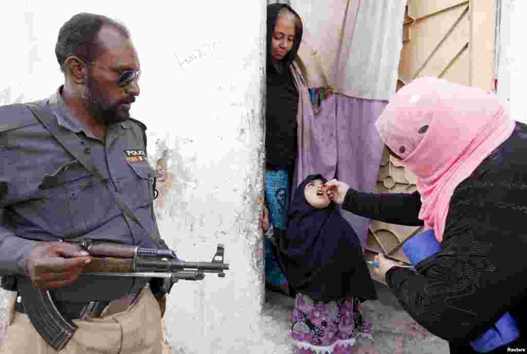 A girl receives polio-vaccine drops on the door step of her family home in Karachi, Pakistan.