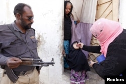 A girl receives polio vaccine drops at the door step of her family home in Karachi, Pakistan, Feb. 15, 2016.