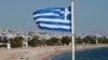 Bendera nasional Yunani berkibar di sebuah pantai, di Athena, Yunani, 28 April 2020. (Foto: Reuters/Goran Tomasevic)