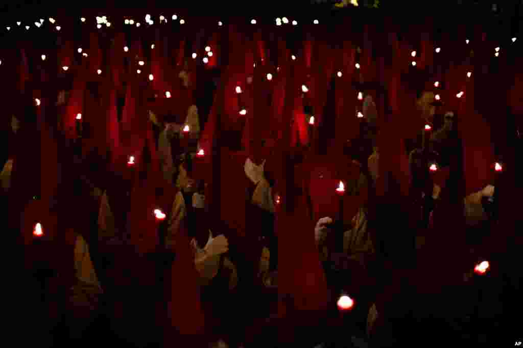 Penitents hold candles as they take part in the &quot;Procesion del Silencio&quot; brotherhood, during the Holy Week in Zamora, Spain.