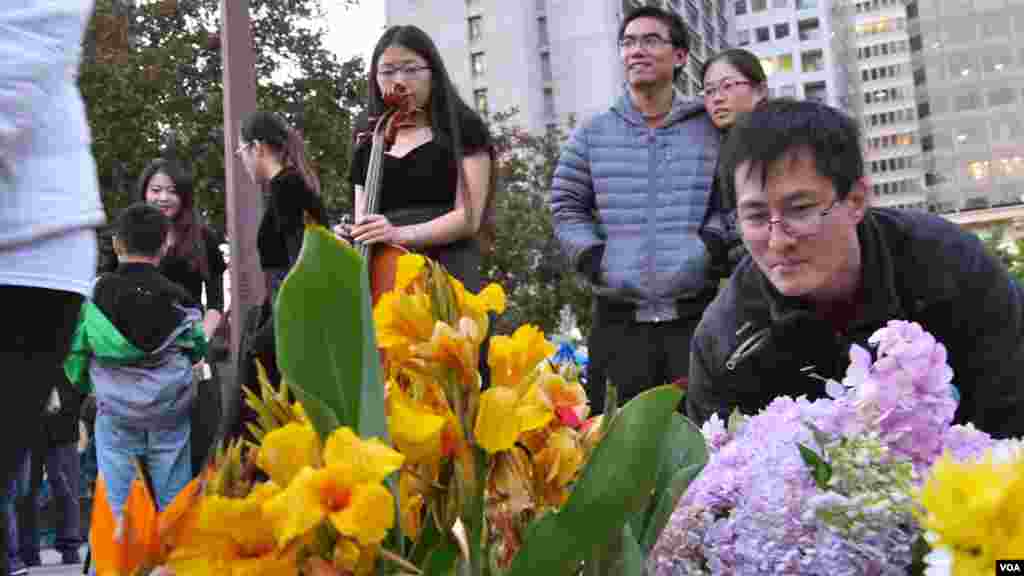 许多青年在民主女神像前献花（美国之音国符拍摄）