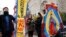 Maro Park, left, of Fairfax, Virginia, holds a sign saying "Congress Must Act Now," next to Paola Marquez and LaRia Land, both of Silver Spring, Maryland, as they stand by a banner of the Lady of Guadalupe, during a march with others in support of the Deferred Action for Childhood Arrivals (DACA) program, on Capitol Hill, Dec. 12, 2017, in Washington. 