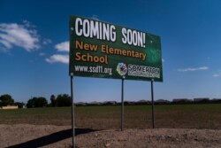 A sign advertising a new elementary school stands along a main street, Aug. 19, 2021, in Somerton, Ariz. The overwhelmingly Hispanic community has grown enough over the last decade that it's also building a new elementary school.