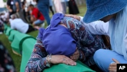 Bosanska Muslimanka tuguje pored lijesa u kojem se nalaze posmrtni ostaci njenog rođaka, žrtve genocida u Srebrenici, u Potočarima, u ponedjeljak, 10. jula 2023.