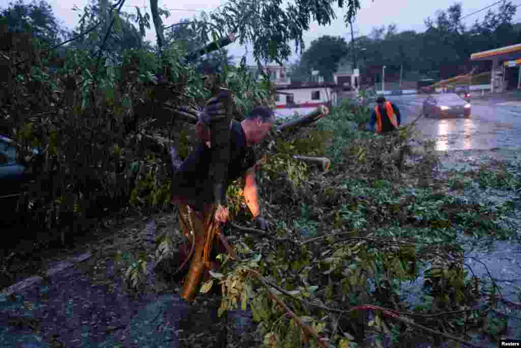 La gente quita un árbol caído después de que el huracán Fiona afectó el área en Yauco, Puerto Rico, el 18 de septiembre de 2022. REUTERS/Ricardo Arduengo