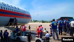 شام کے ایک ہوائی اڈے پر کارکن روسی طیارے سے آنے والا امدادی سامان اتار رہے ہیں