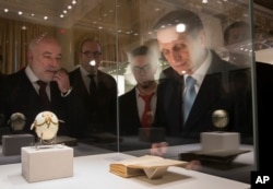 FILE - Sergei Naryshkin, the Chairman of the State Duma and the Chairman of the Board of Trustees of the Faberge Museum, right, and Russian businessman Viktor Vekselberg, the founder of the Faberge Museum, left, examine unique items from the personal archive of the Yusupovs, one of the most powerful and richest Russian noble families, which were returned to Russia and donated to the State Archive of the Russian Federation in St. Petersburg, Russia, Feb. 13, 2015.